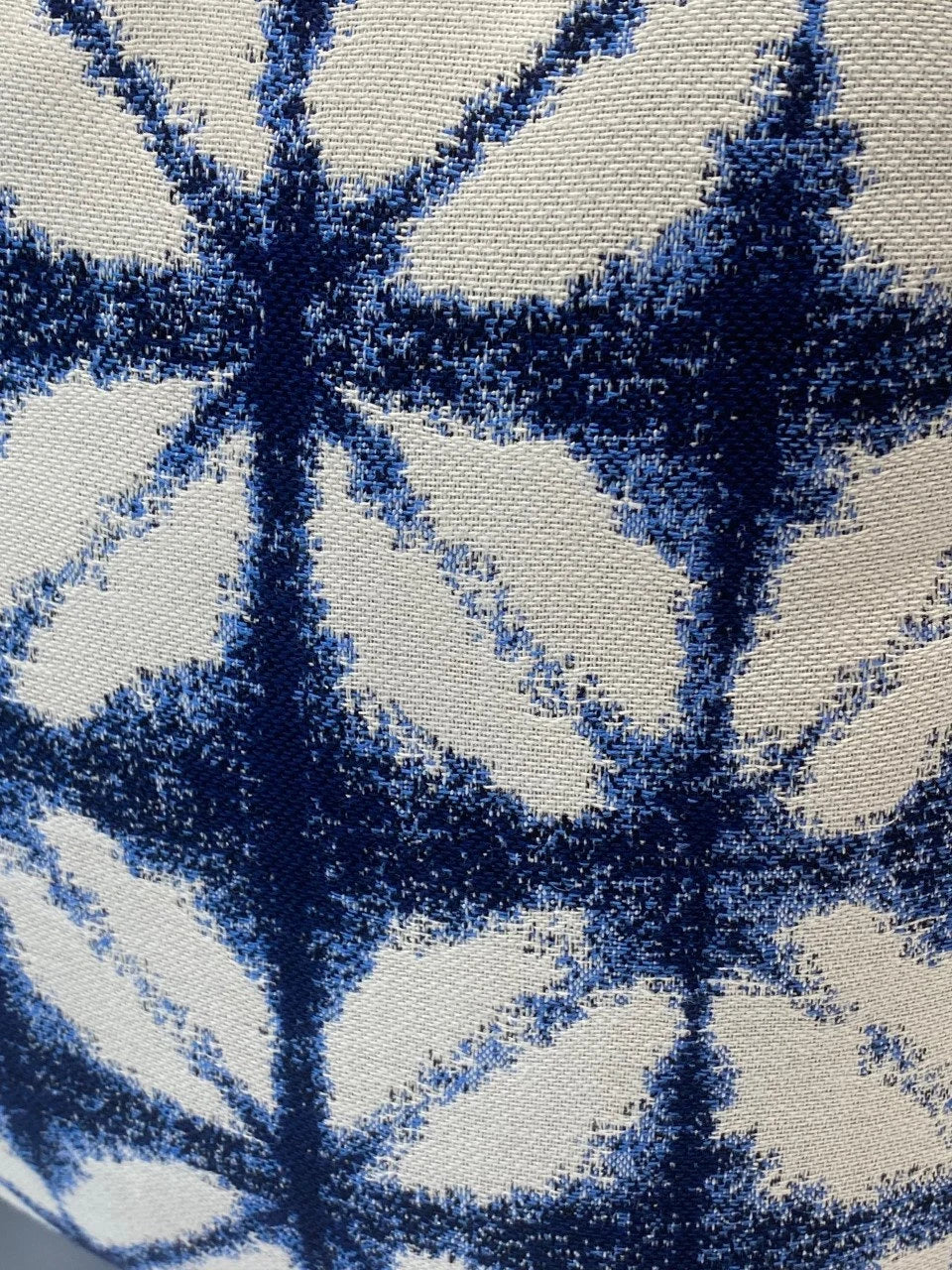 Close-up of a blue and white patterned fabric -Decorative pillow with blue and white traditional Japanese Shibori dyeing pattern on a plain background