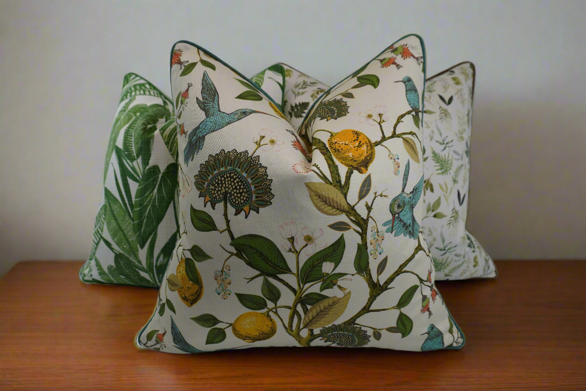 Decorative pillow with a teal hummingbird and floral pattern on a lemon tree on an Ivory-beige background