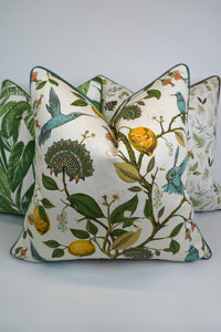 Decorative pillow with a teal hummingbird and floral pattern on a lemon tree on an Ivory-beige background