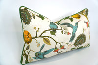 side view of a Lumbar size Decorative pillow with a teal hummingbird and floral pattern on a lemon tree on an Ivory-beige background and Green Welt/Piping along the edges of the Pillow