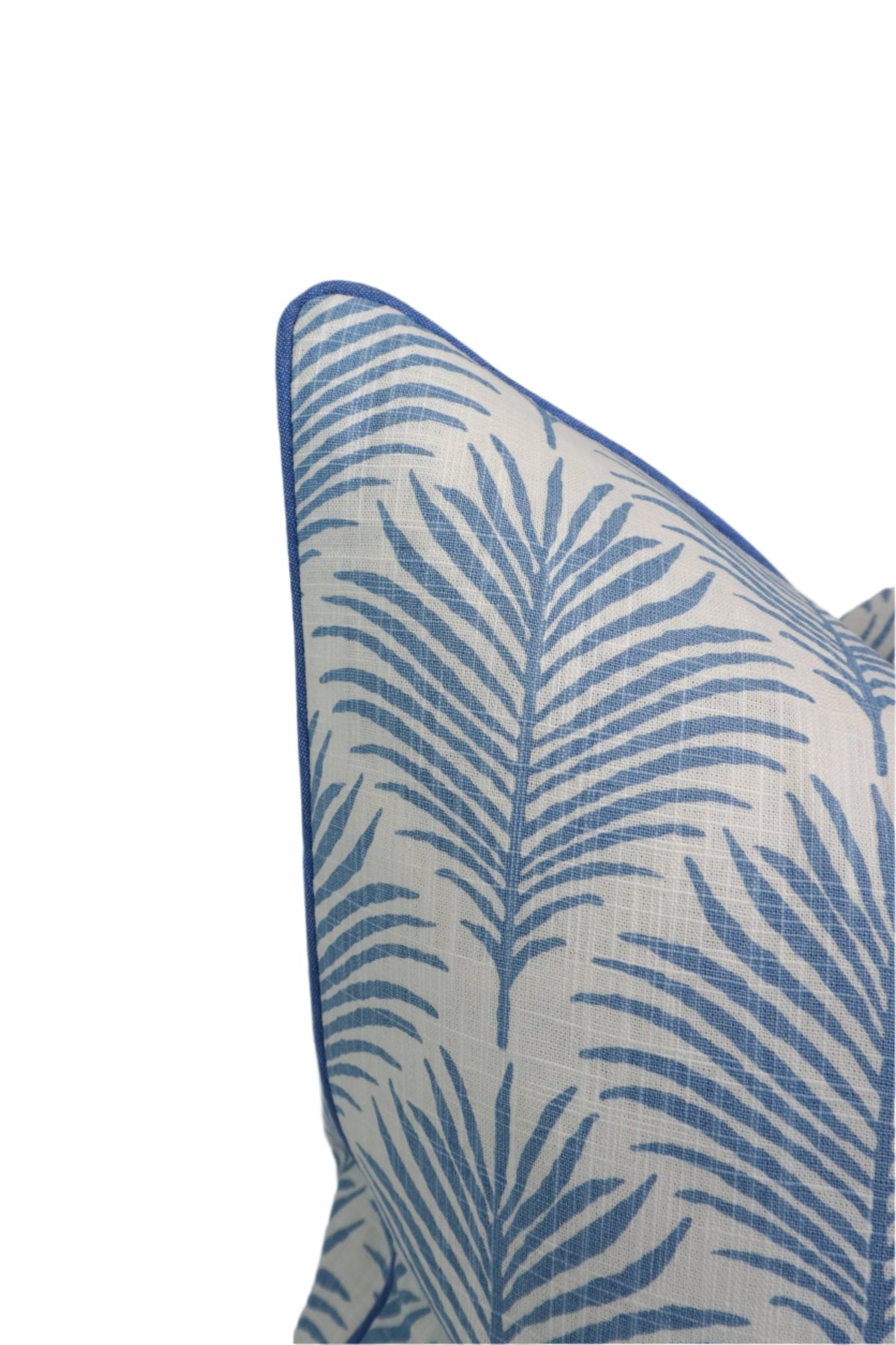 Close-up of a decorative pillow with blue palm leaf pattern on a white background