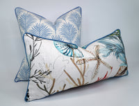 Two decorative pillows with floral and nature-themed patterns on a white-off white background