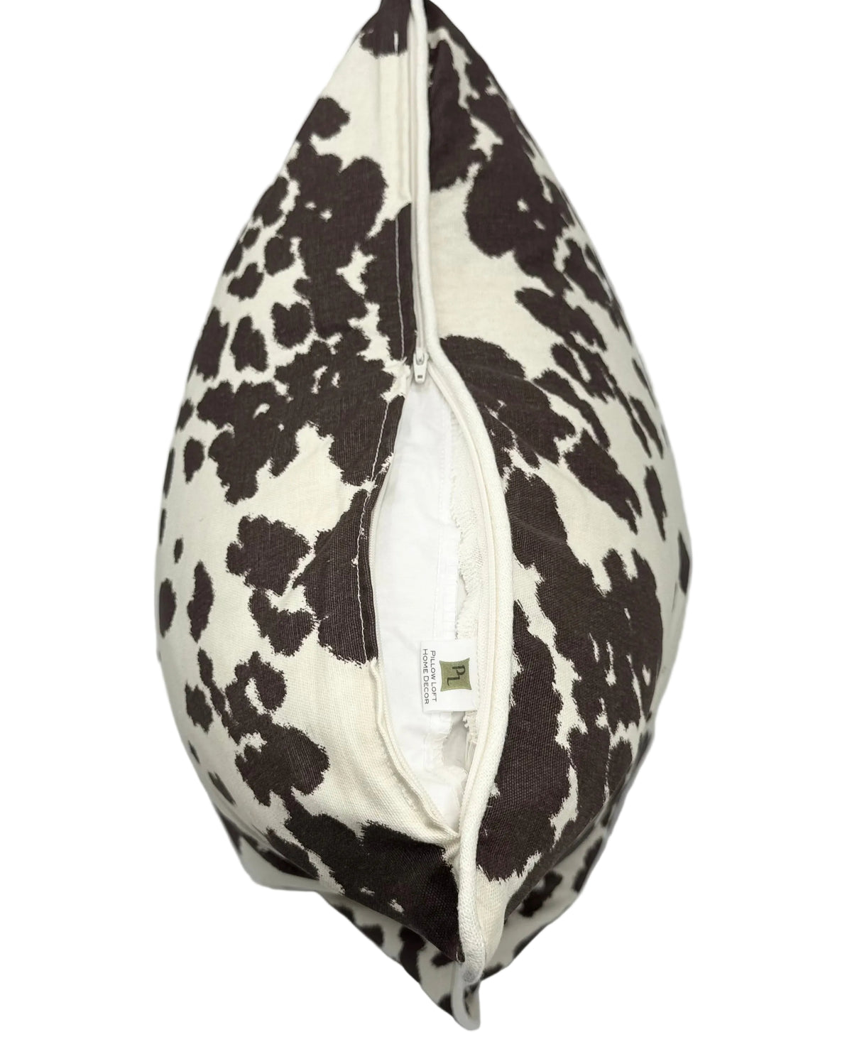 A square decorative throw pillow with a cow print pattern in dark brown and Cream, shown with its zipper opening on bottom to reveal the white pillow insert.