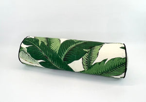 Roll-shaped pillow with green leaf pattern on a cream background with Black welt/piping