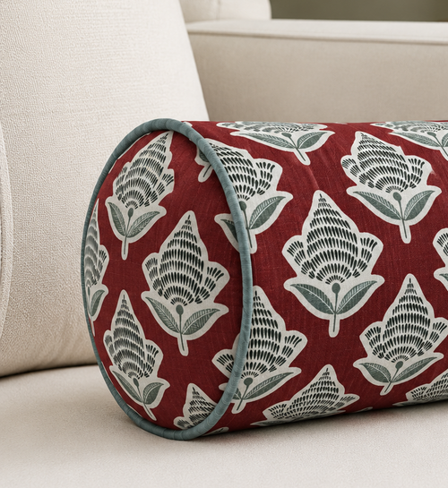Decorative bolster pillow with floral pattern on a beige sofa