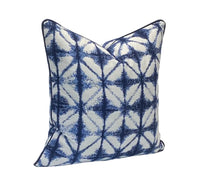 Decorative pillow with blue and white traditional Japanese Shibori dyeing pattern on a plain background